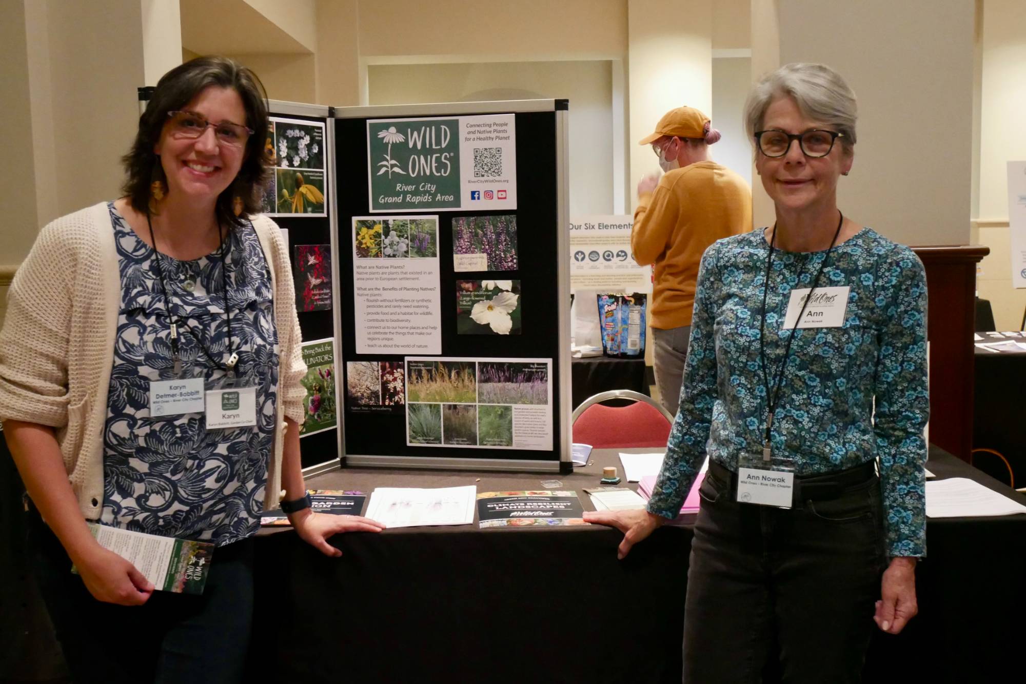 Two educators at their table showing their action project